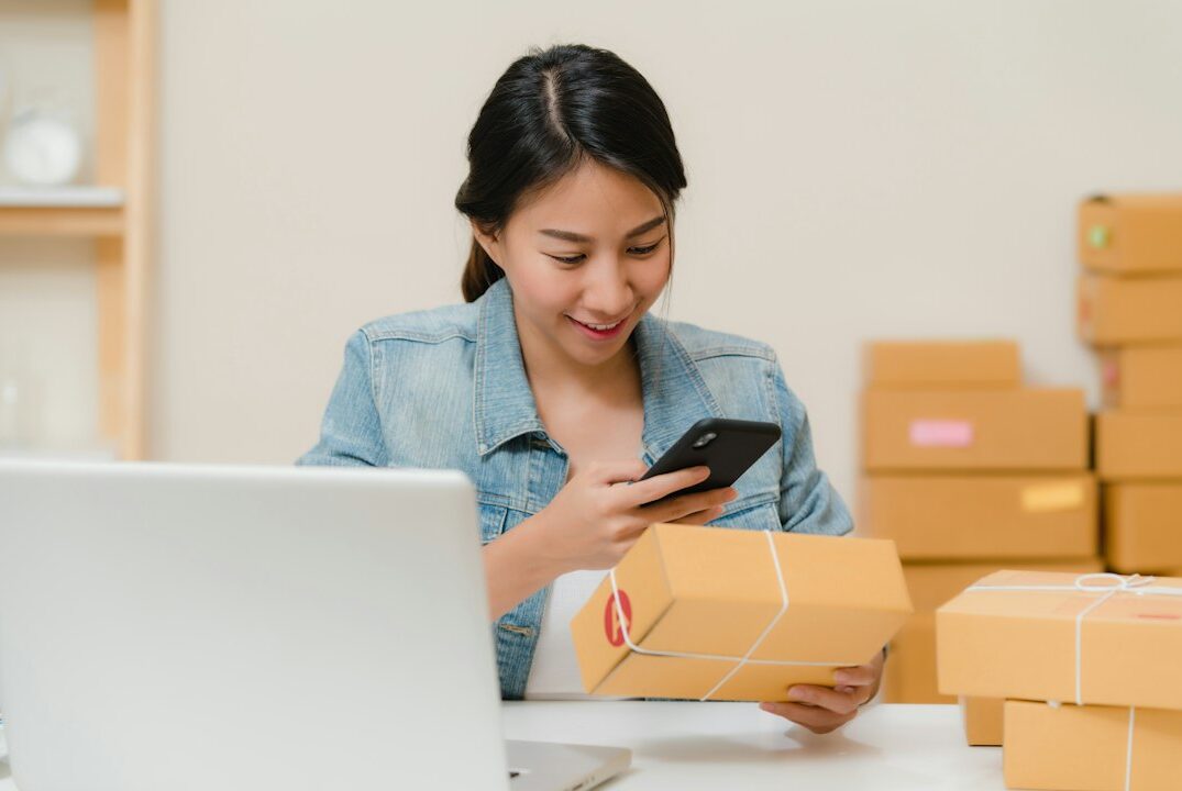 Mujer emprendedora revisando un pedido de su tienda online con el celular