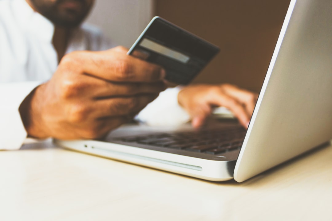Persona usando laptop y tarjeta para hacer una compra online, representando publicidad de ecommerce en Meta Ads