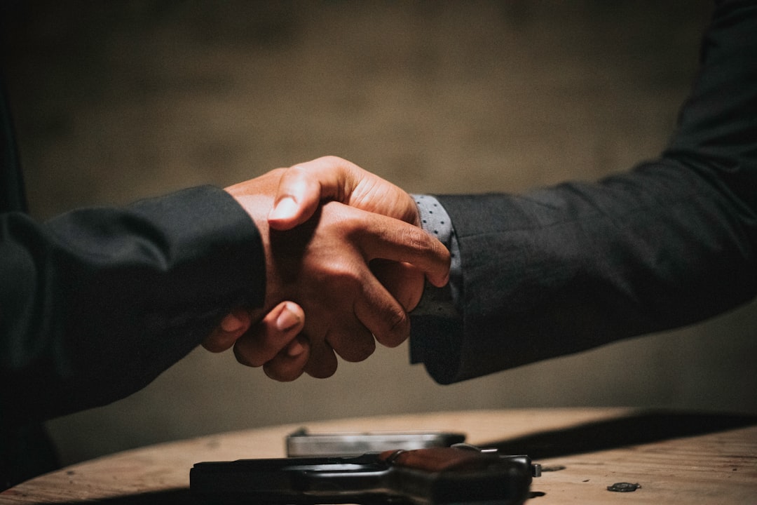 Dos personas dandose la mano tras cerrar un acuerdo inmobiliario