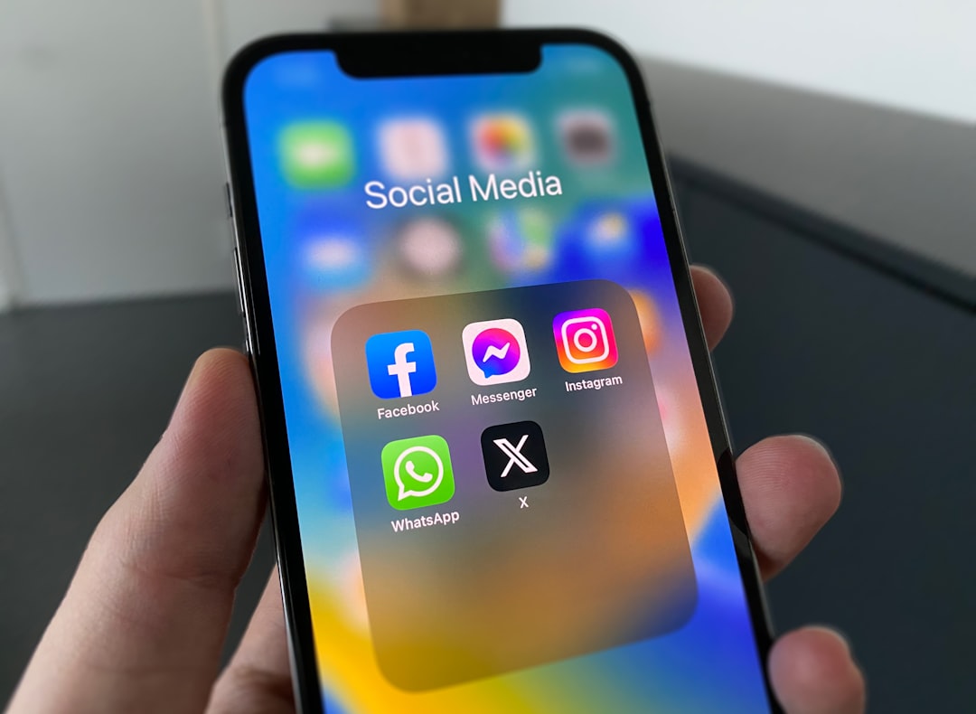 Persona sosteniendo un celular con iconos de redes sociales en la pantalla, representando publicidad en Meta
