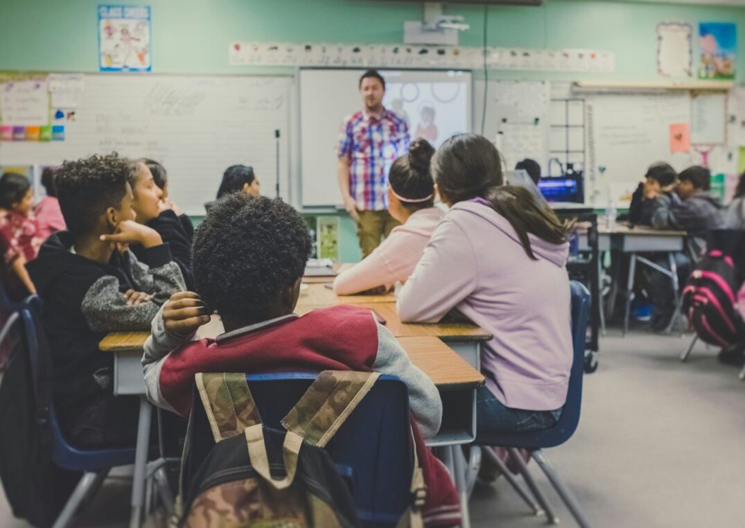 Profesor presentando en un salón de clases con estudiantes atentos