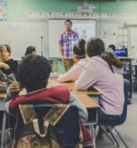 Profesor presentando en un salón de clases con estudiantes atentos