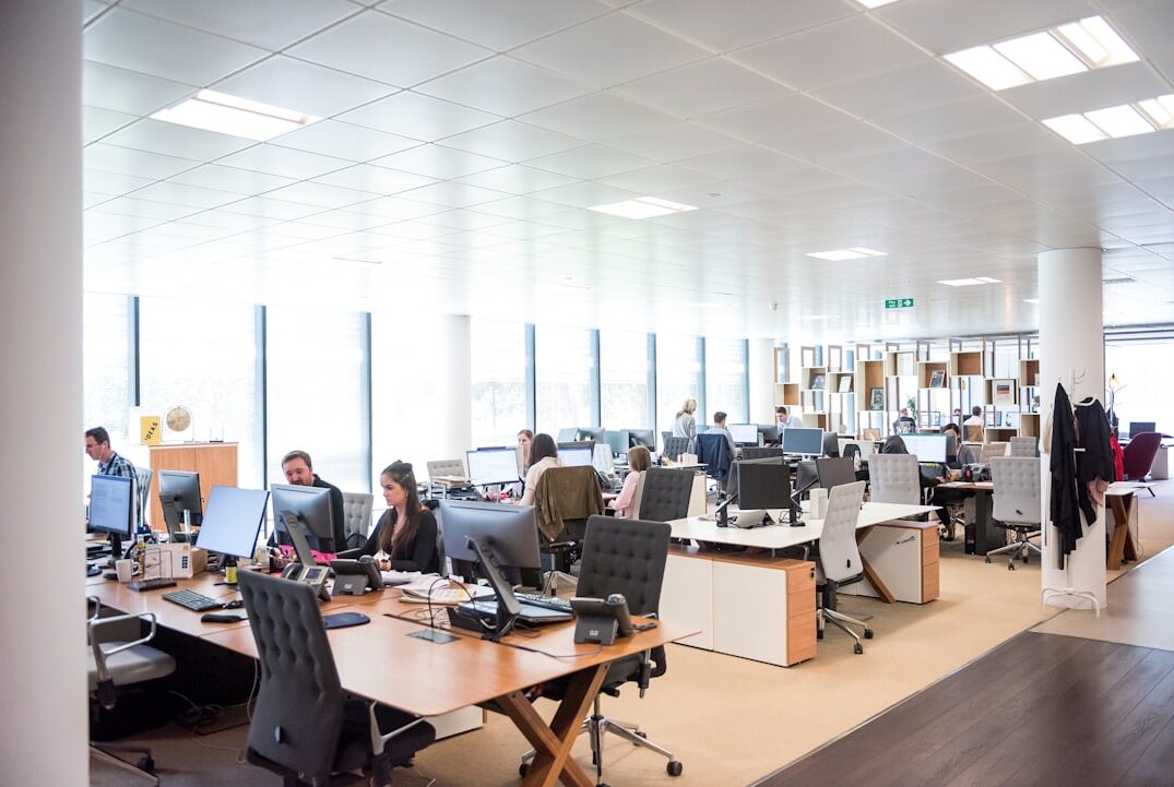 Equipo de trabajo en oficina moderna usando computadores, representando la gestión digital de una inmobiliaria