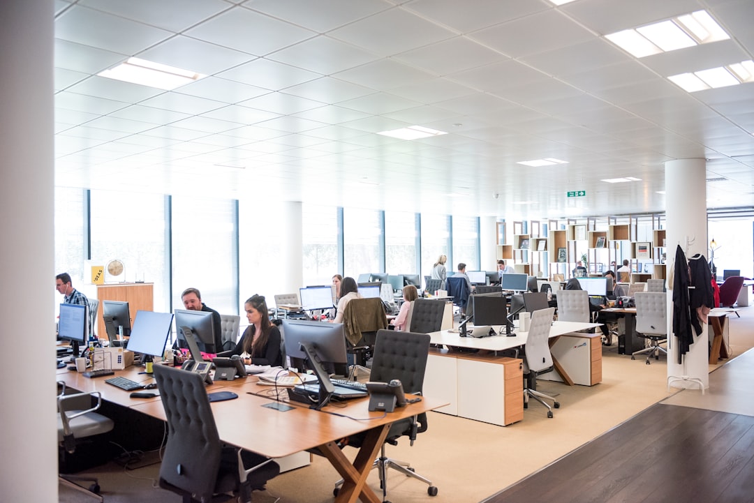 Equipo de trabajo en oficina moderna usando computadores, representando la gestión digital de una inmobiliaria