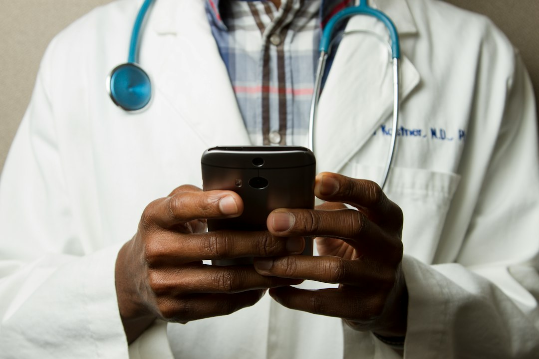 Profesional de la salud revisando su celular, representando la atencion por WhatsApp con agentes de IA en consultorios