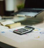 Calculadora y laptop sobre un escritorio, representando la automatización de procesos contables y de facturación