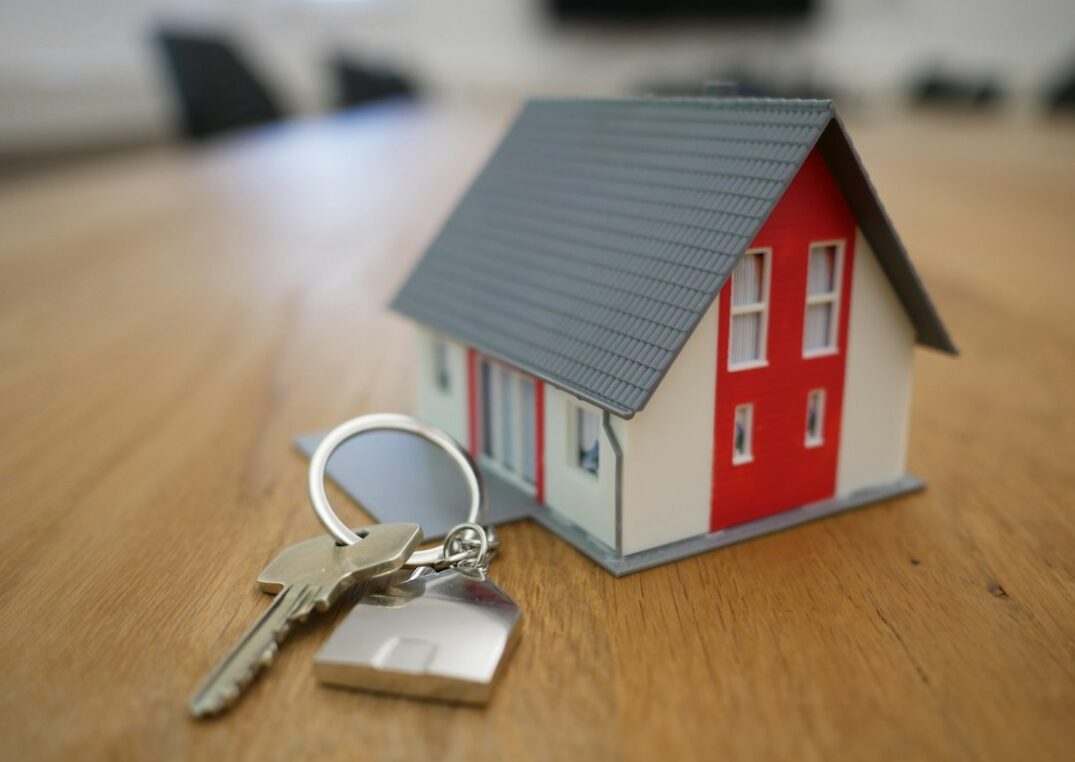 Casa en miniatura sobre un escritorio, representando el sector inmobiliario